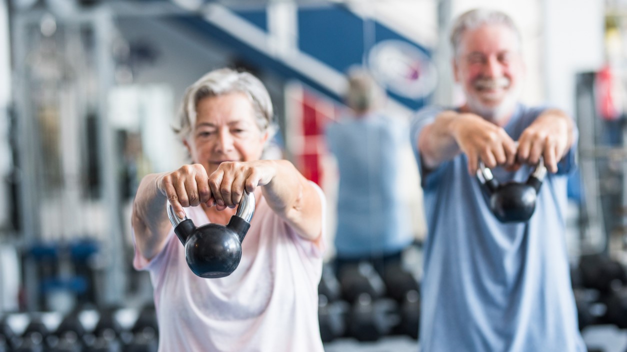 A person lifting weights in a gym, illustrating research on resistance training and longevity.